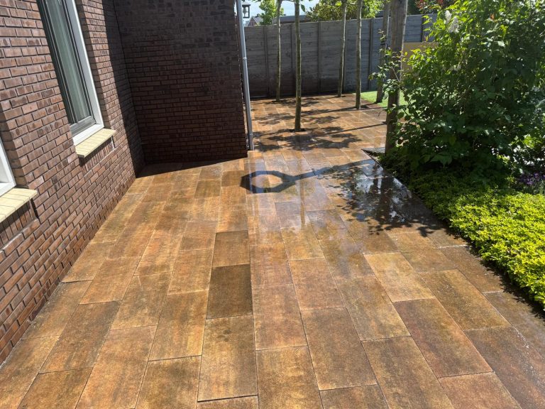 Tuin met warme tegels en groene borders en beplanting